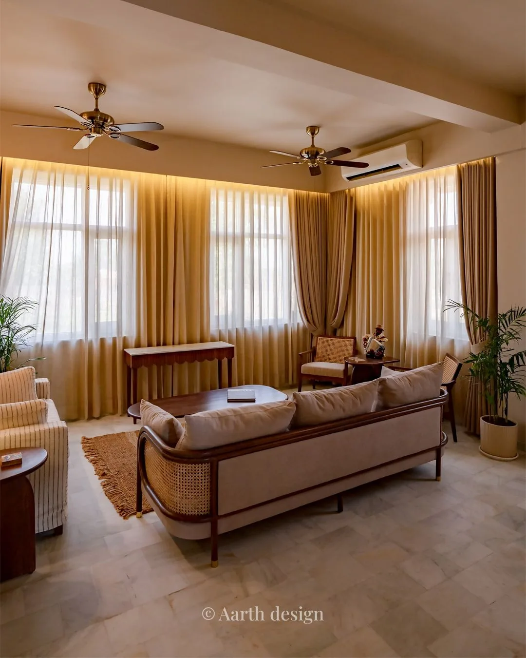 Living room with tall curtained windows, a console table and twin ceiling fans