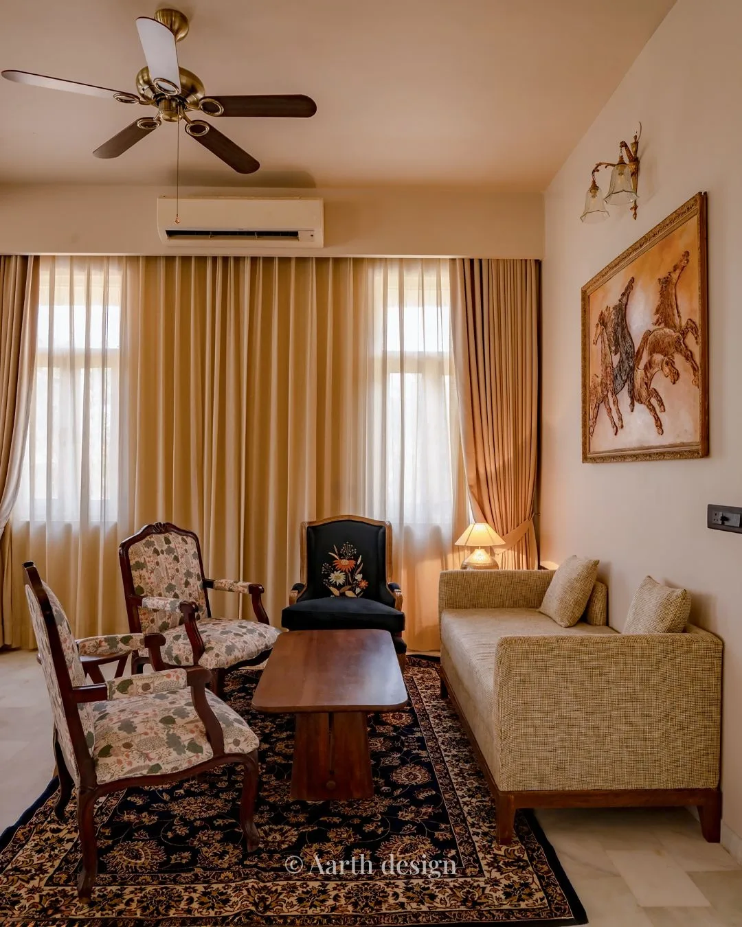 Living room with floral armchairs and a striped sofa set beneath a framed equestrian painting