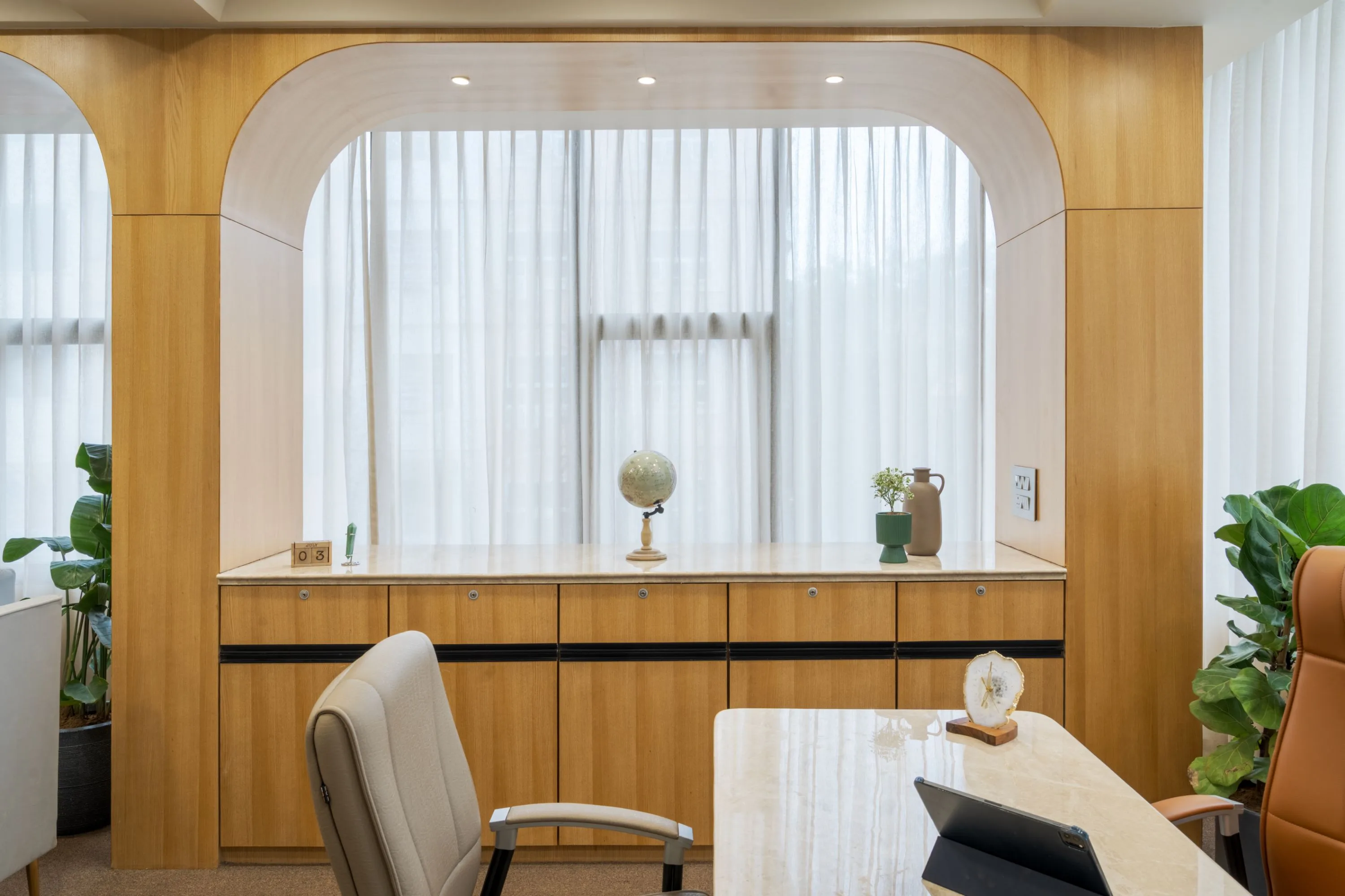 Arched wood niche with a marble backdrop, a small globe and curios on the counter