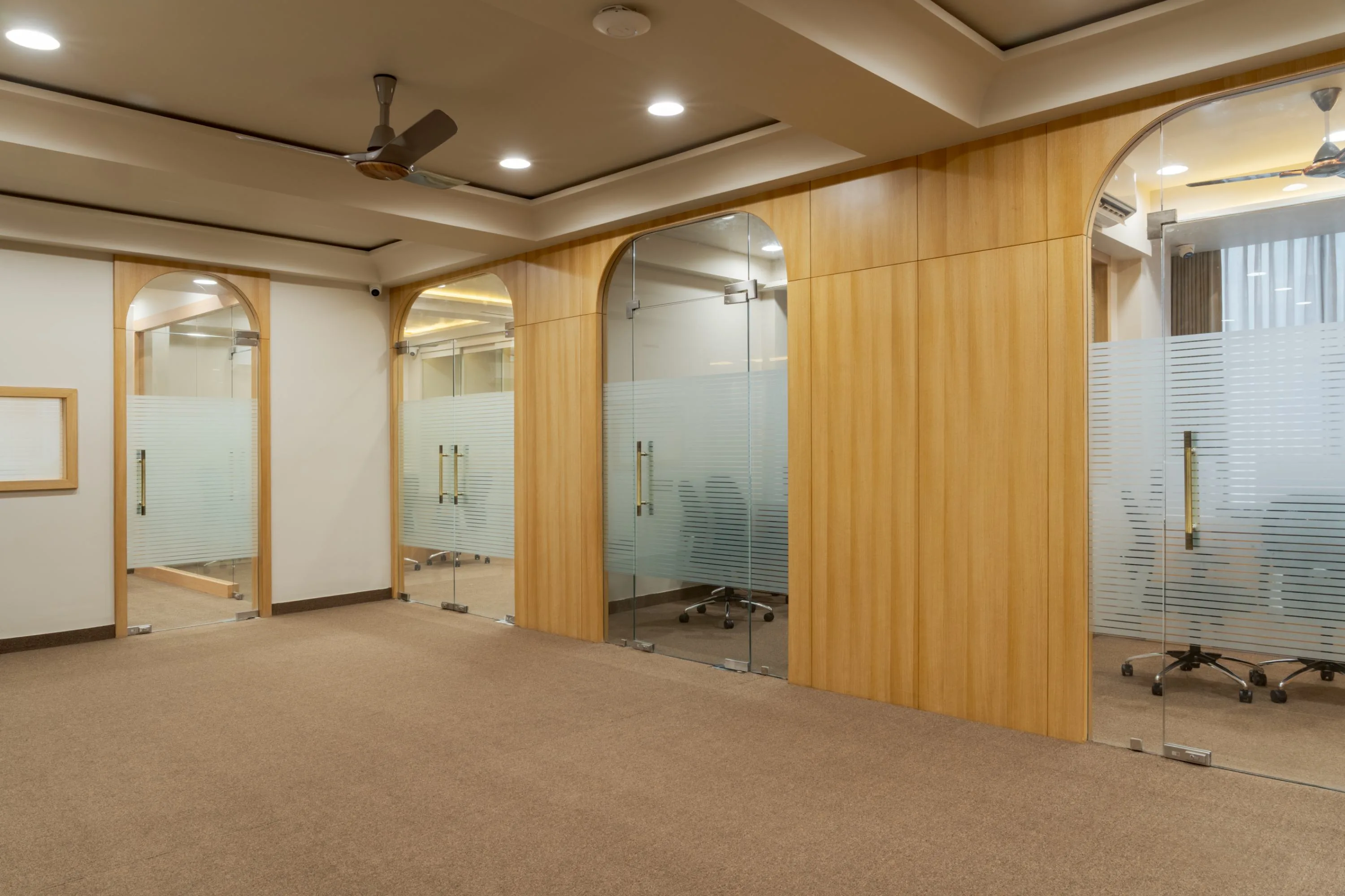 Row of arched frosted-glass doors along the meeting room corridor