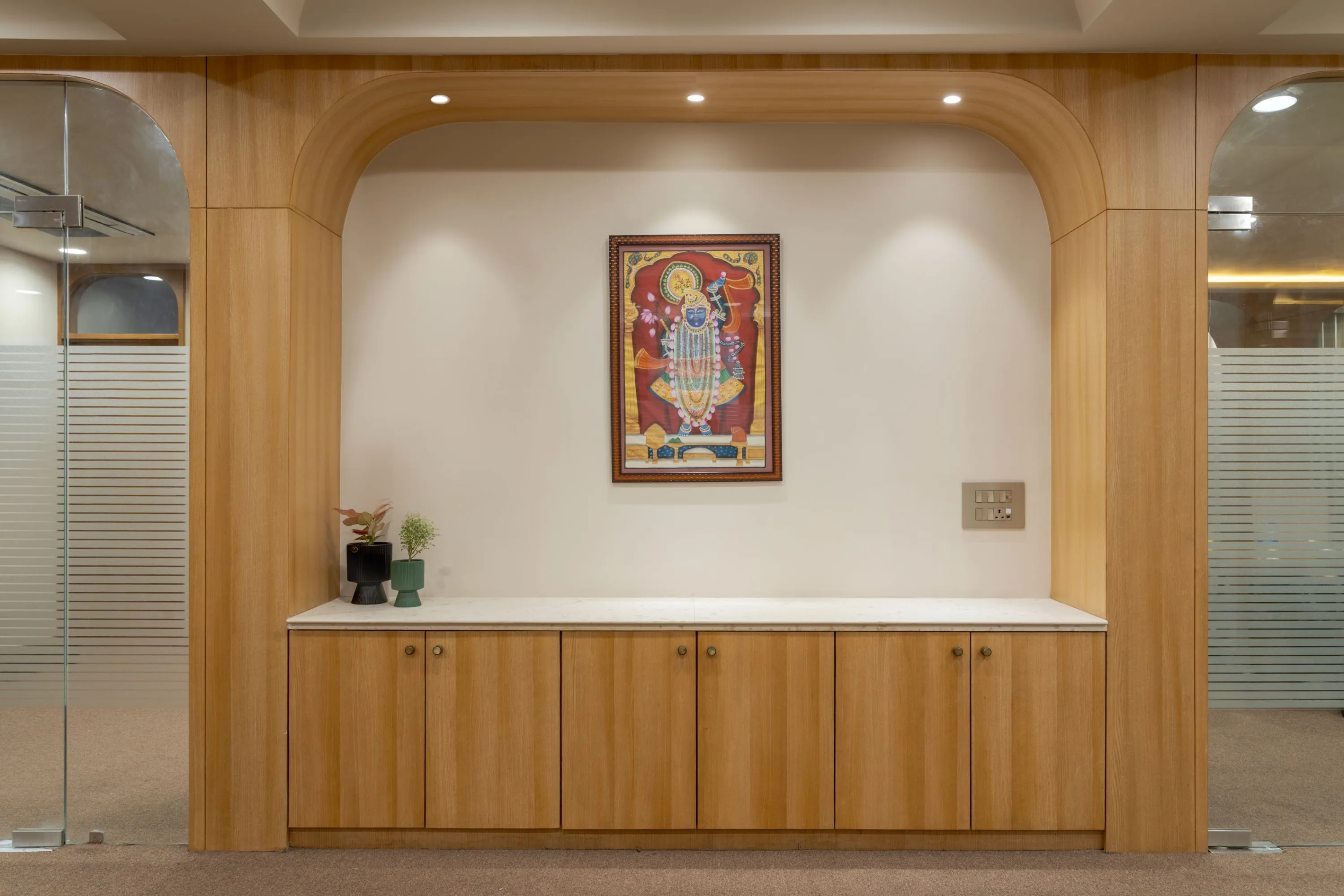 Arched alcove with a Shrinathji painting above a marble console