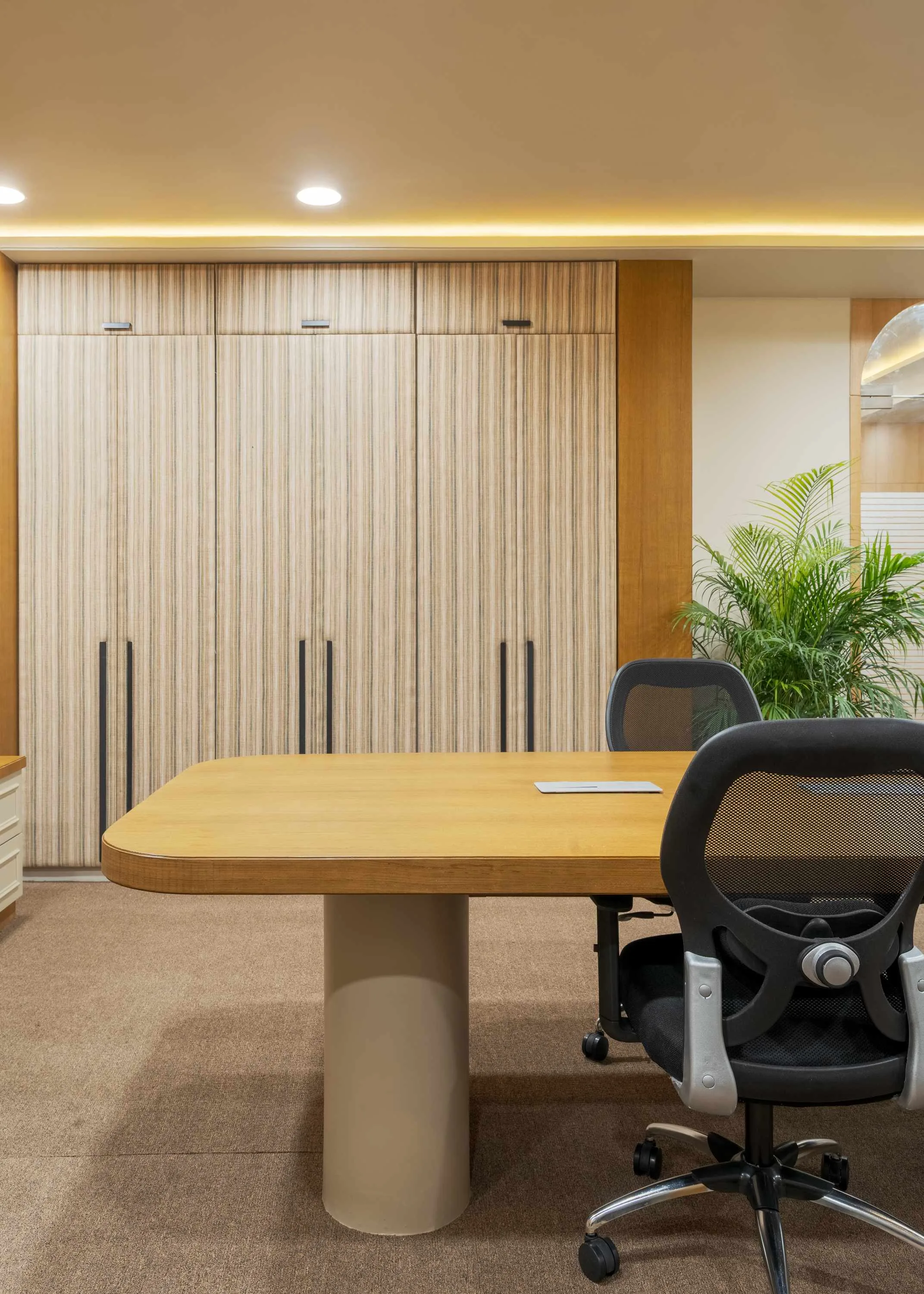 Boardroom table detail against a striped wood-panelled wardrobe wall