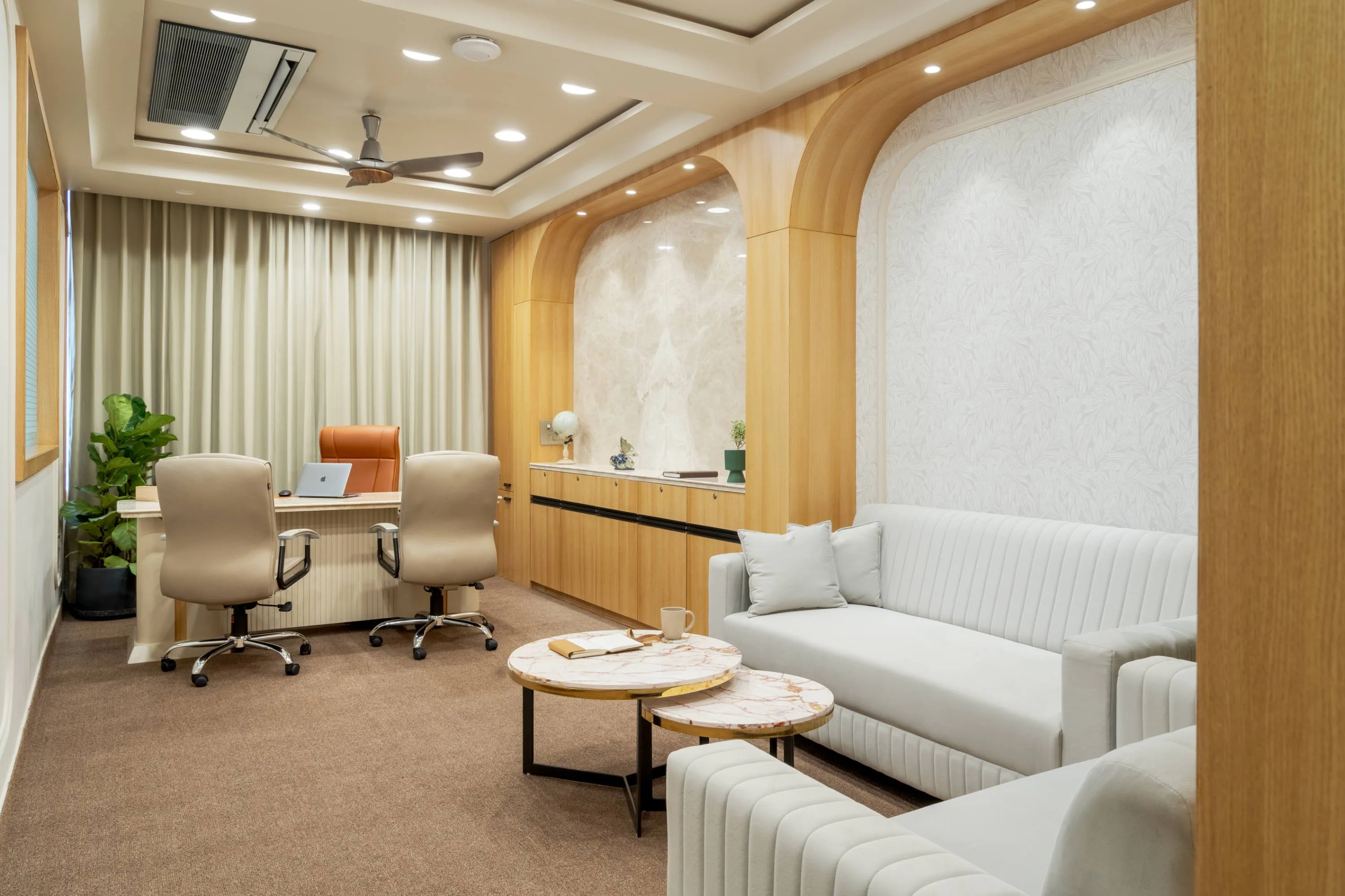 Director's cabin opening into a marble-niched sitting area with a curved sofa