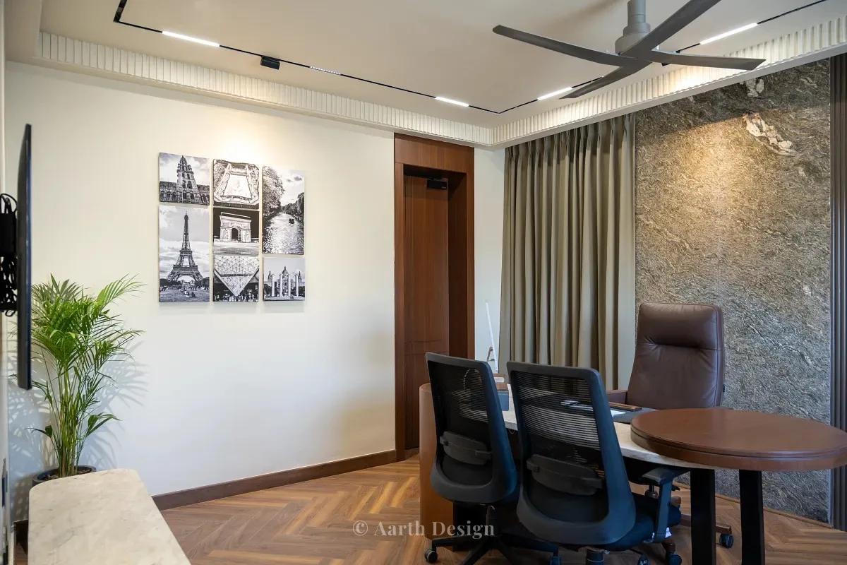 Cabin with a stone-clad feature wall, a round meeting table and a set of framed Paris prints