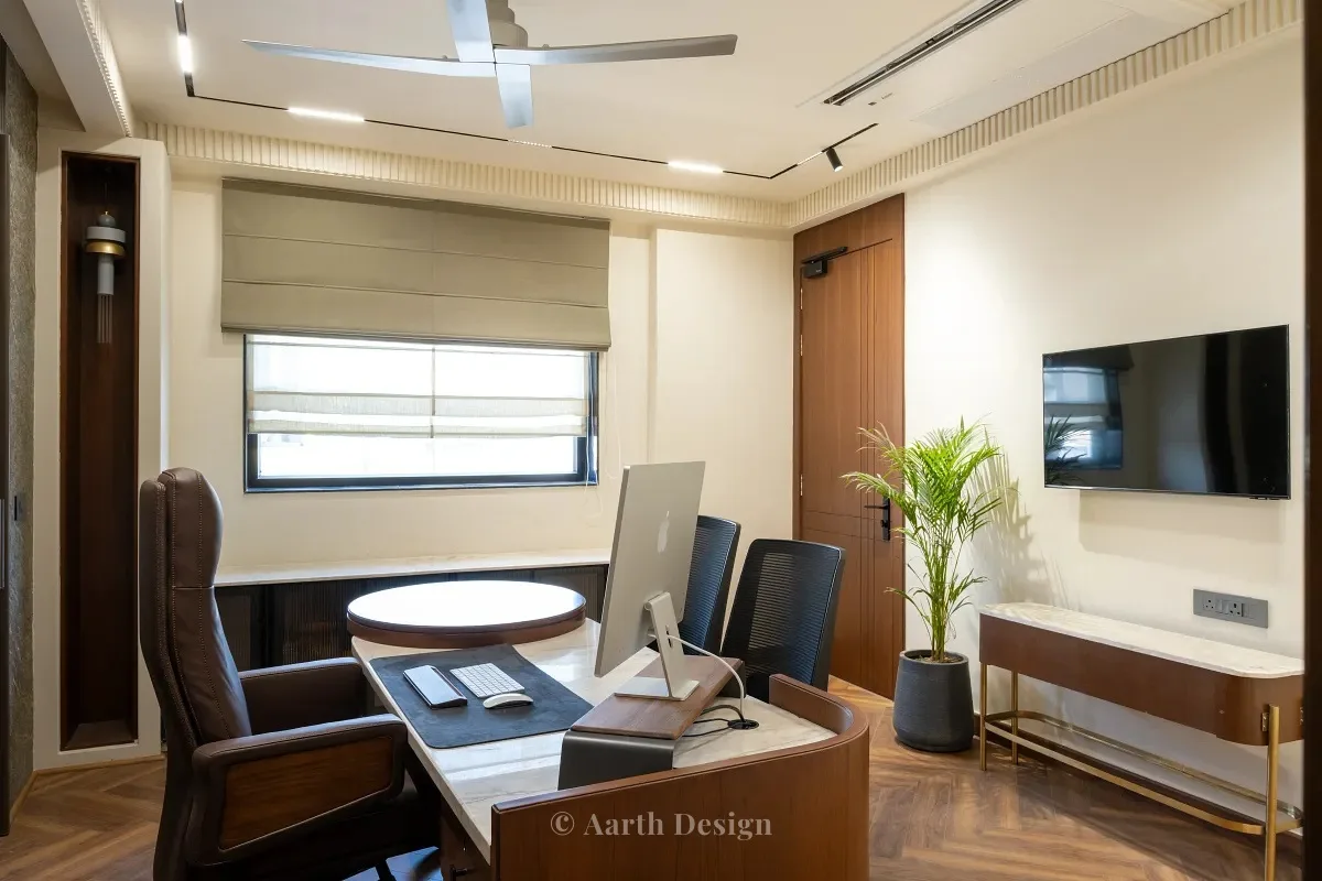 Cabin with a walnut desk facing a wall-mounted television and a slim brass-legged console