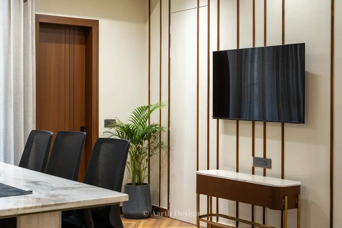 Cabin with a television set between slim timber battens above a brass-legged console