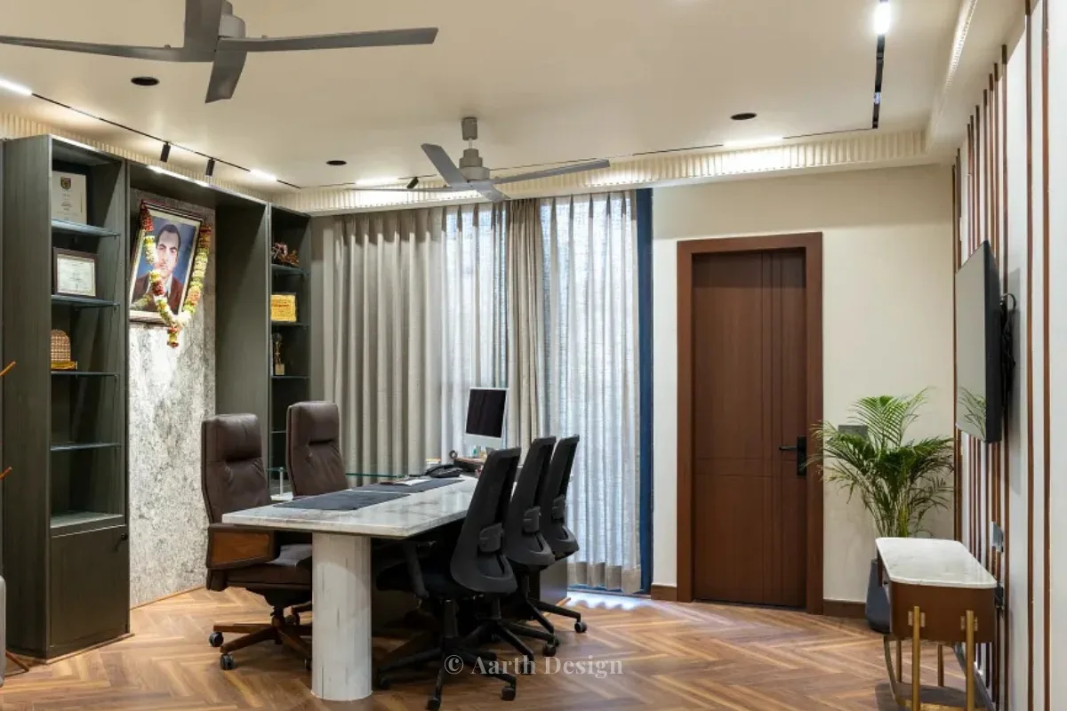 Cabin with a marble-topped desk before a dark bookshelf wall and full-height curtains