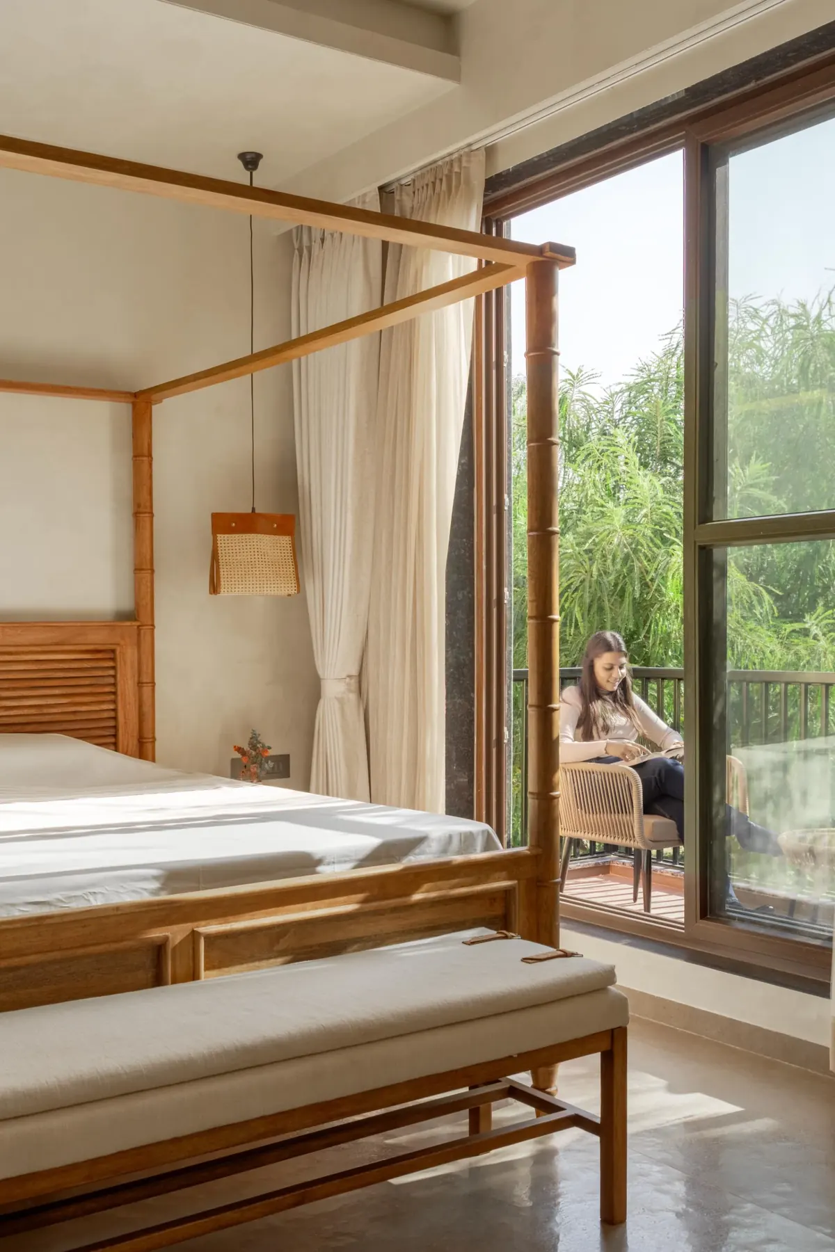 Canopied bedroom opening onto a balcony among the treetops