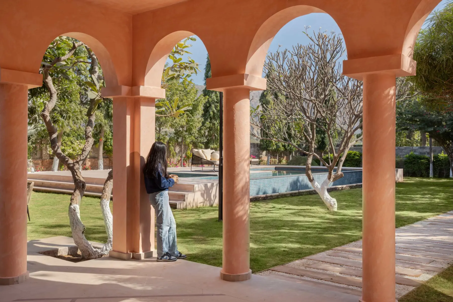Arched veranda colonnade opening onto the garden and pool