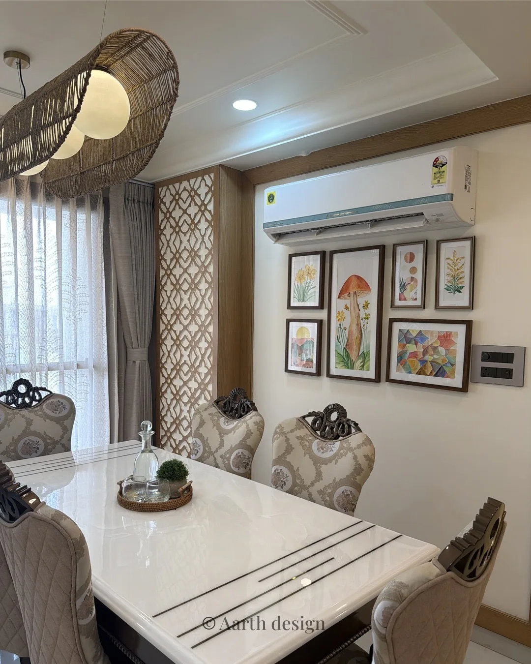Dining table in white marble with a rattan pendant and a gallery of framed prints