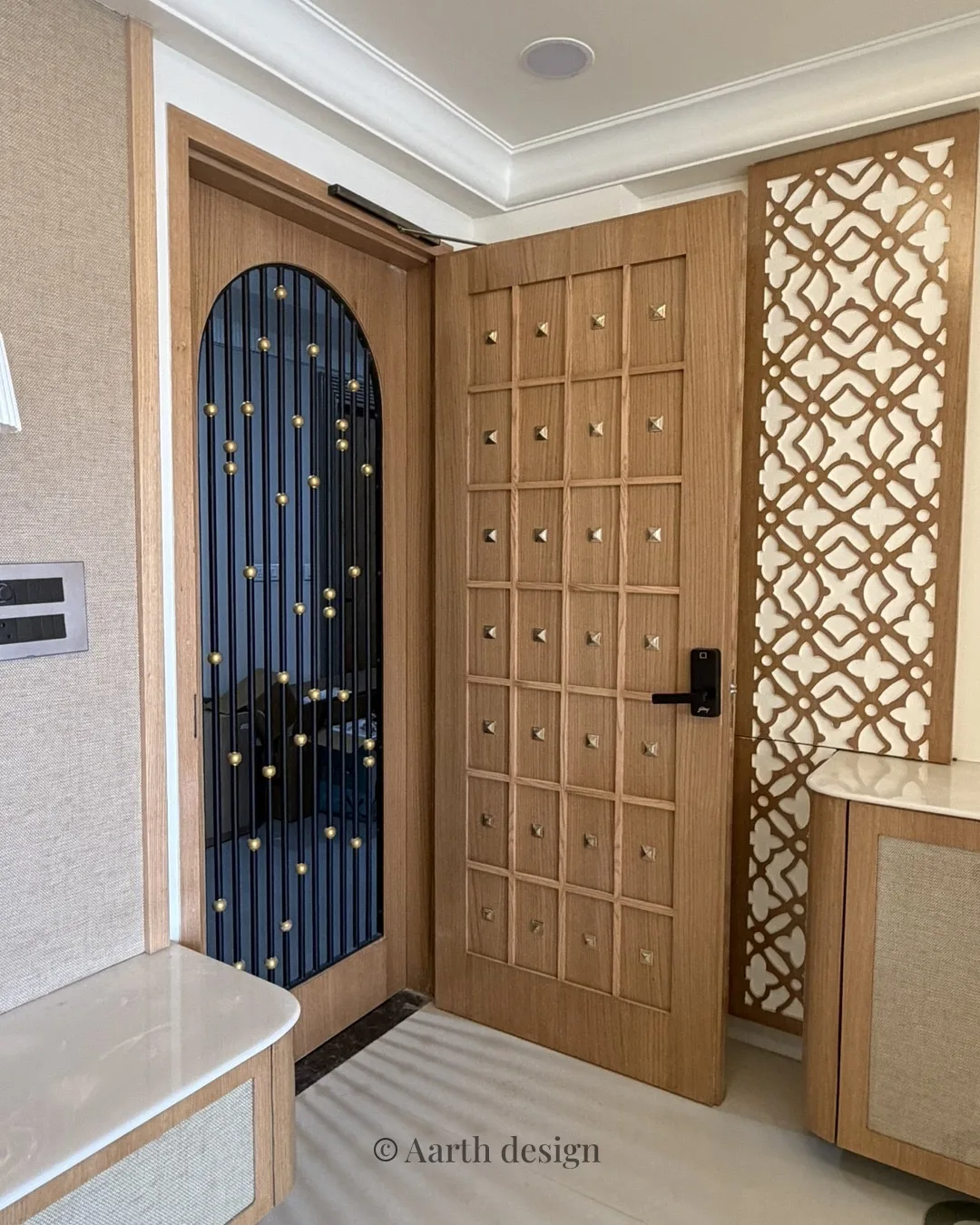 Entrance door in studded oak beside a carved jaali panel