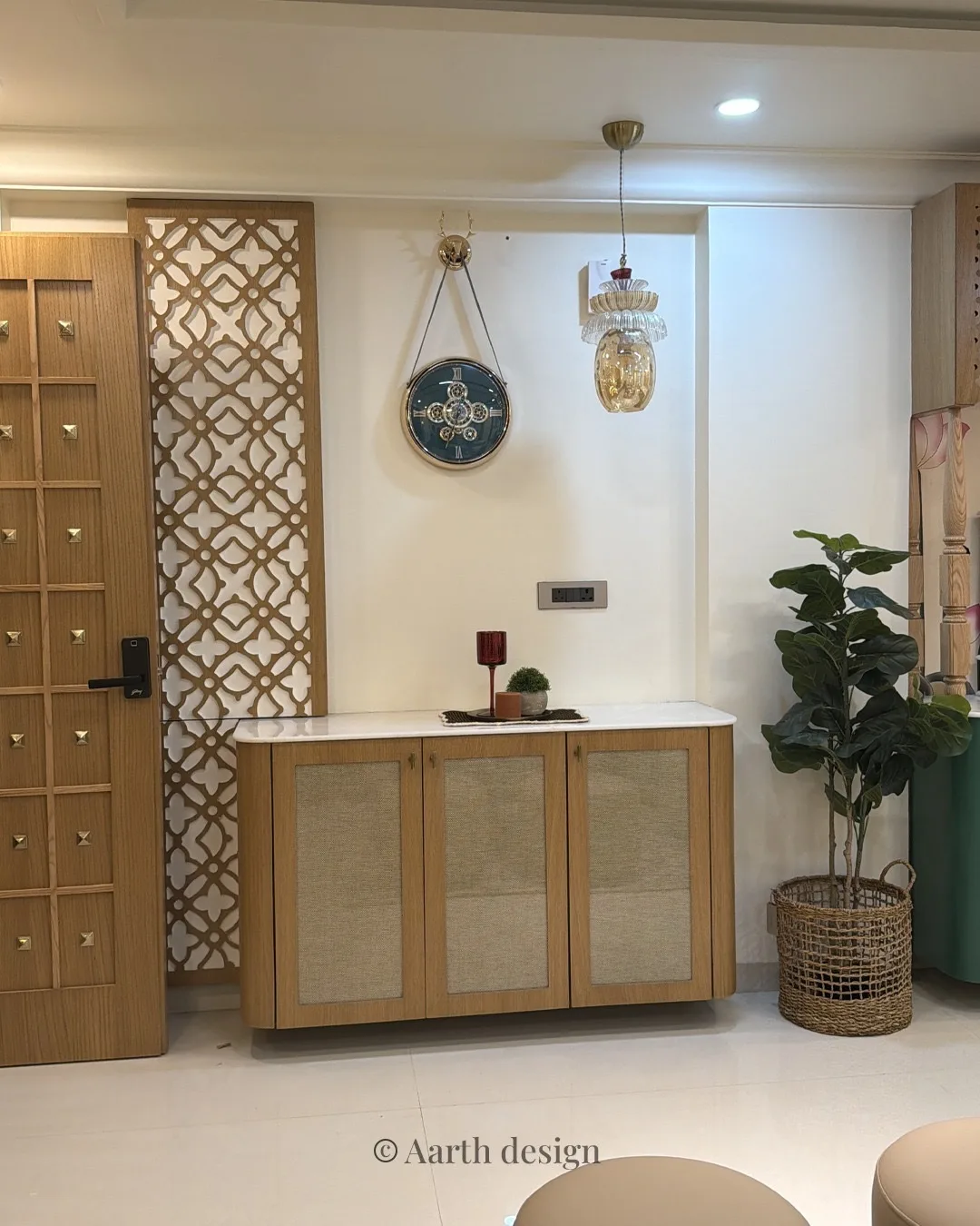 Foyer with a cane-fronted shoe cabinet beside a carved jaali panel