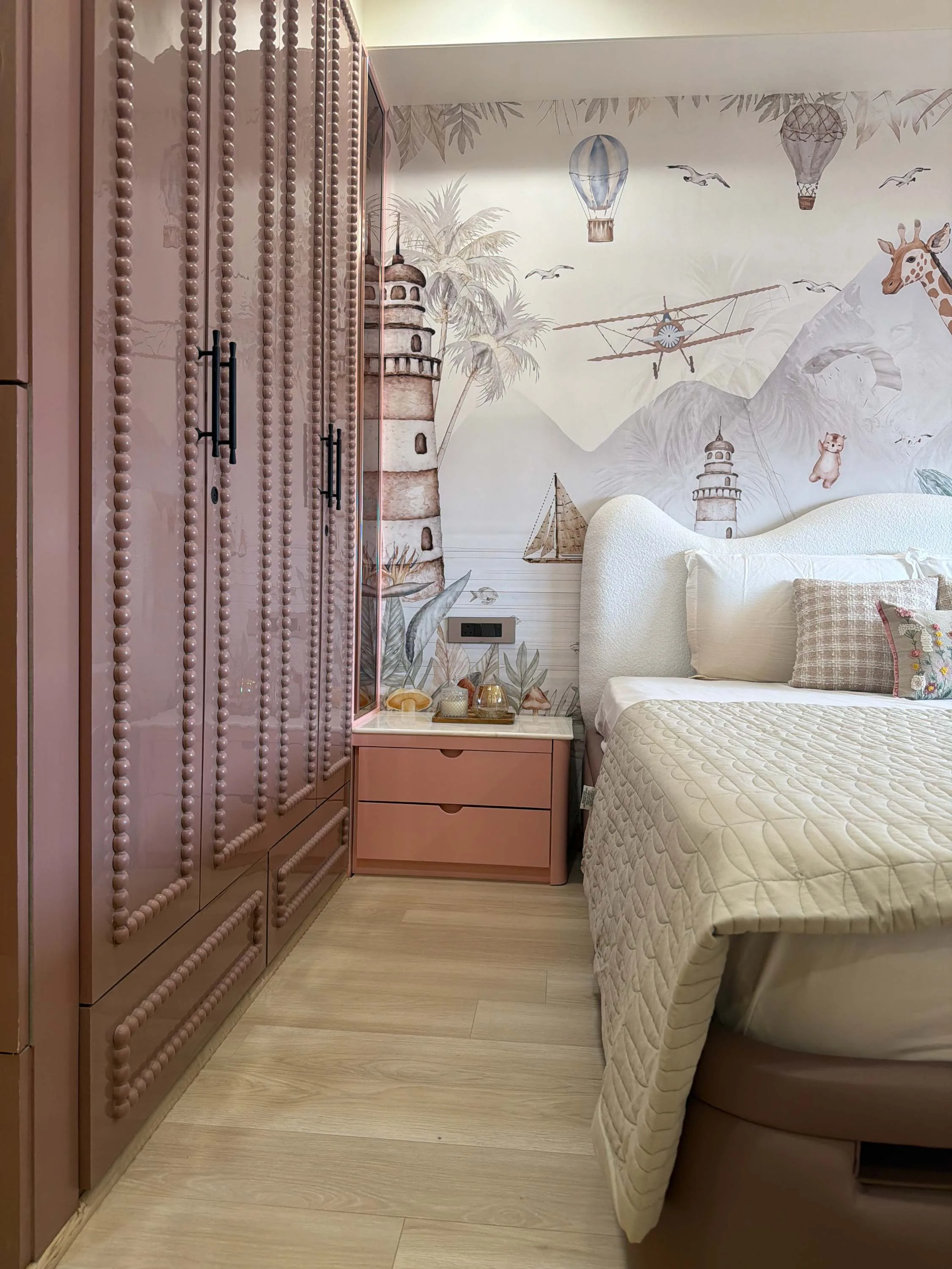 Children's bedroom with a hot-air-balloon mural beside a tall louvred wardrobe