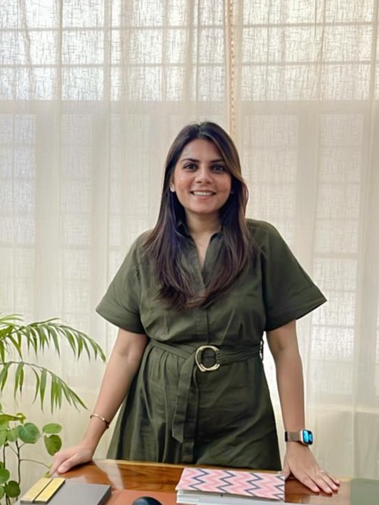 Sanjana Gupta, founder of Aarth Design, standing at her studio desk with material samples